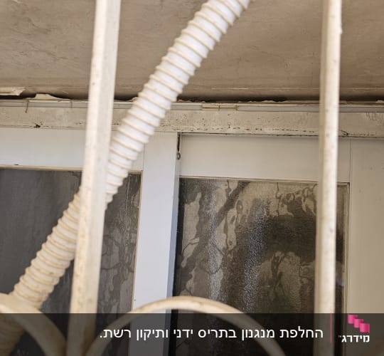 חלון עם תריסים מאחורי סורגים ולולאה